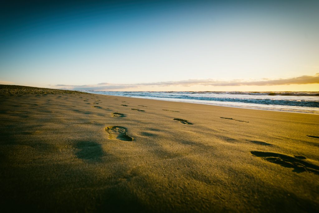 Foot imprints on sand near a beach