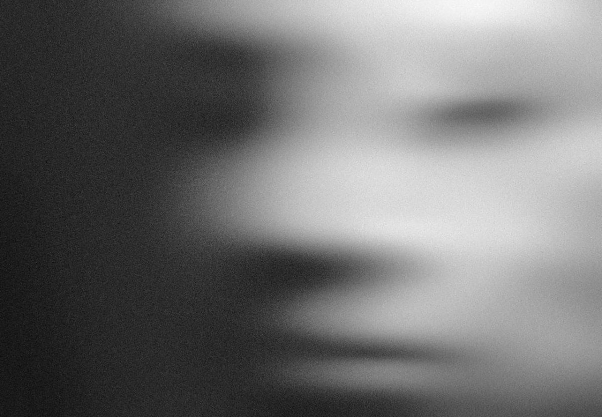 Black and white photo of a blurred face.